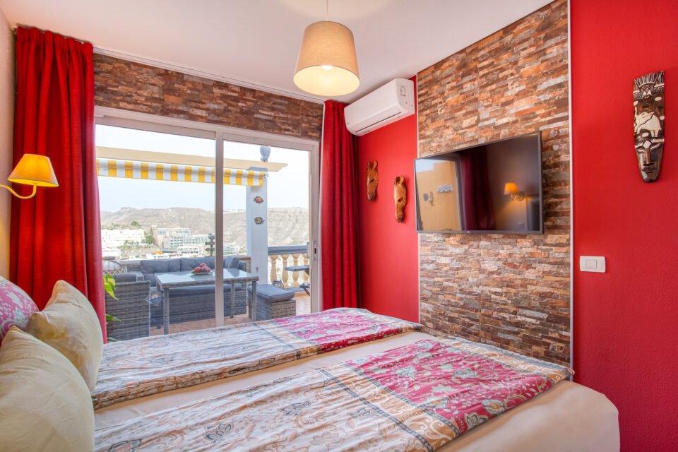 Apartamentos Monseñor, Playa del Cura - bedroom with a tv on a wall